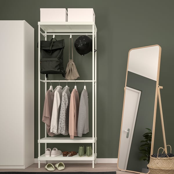 White MACKAPÄR coat rack with shelves & hooks by green wall, holding items, beside tall mirror.