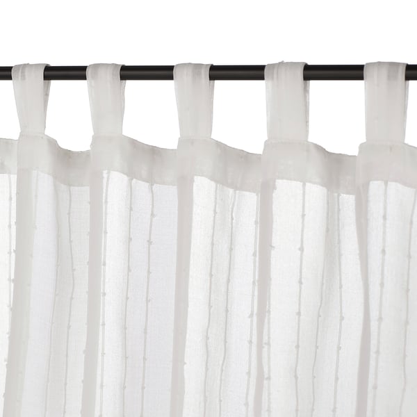White tab top curtains on black rod, hanging partially closed, filtering light.