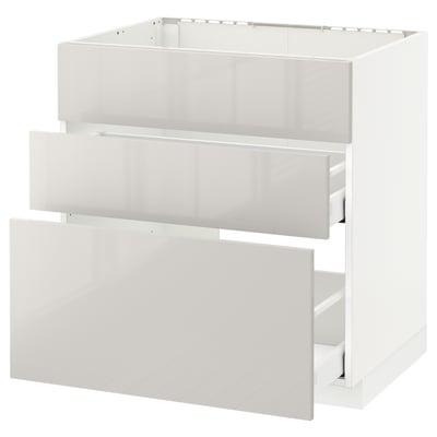 Modern kitchen: white METOD cabinet with glossy drawers. Three open drawers, sleek design.