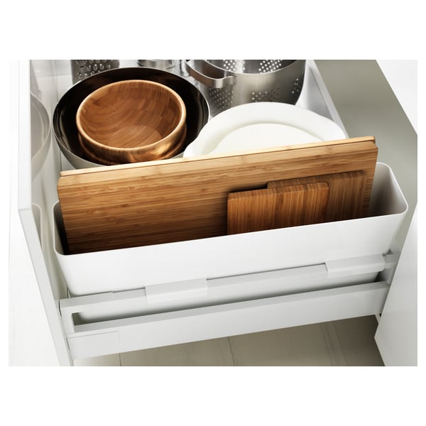 White kitchen drawer with wooden cutting boards and bowls, showcasing organised storage.