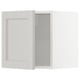 White METOD kitchen cabinet with beige frame and glass door.