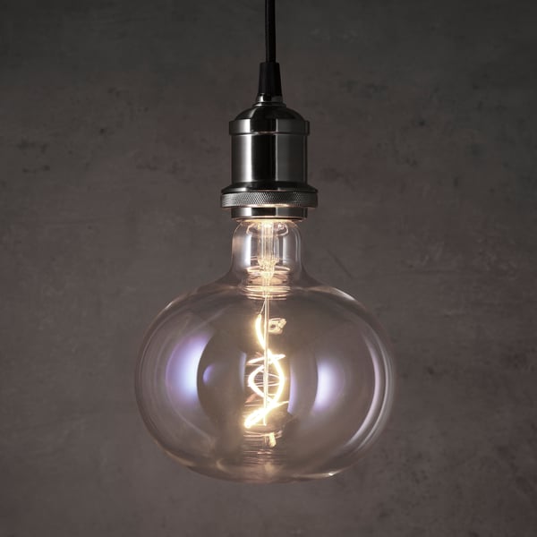 A glowing, bubble-like led bulb with a spiral filament, emitting warm light.