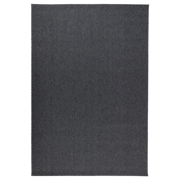 A dark grey MORUM rug. Its flat-woven, rectangular, and made of 100% polypropylene. Suitable for both indoor and outdoor use in moderate climates.