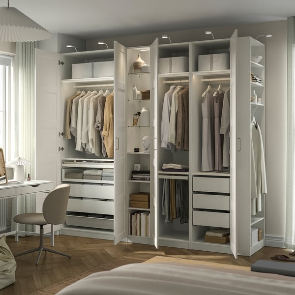Modern wardrobe with clothes, drawers, & shelves, featuring internal lighting and adjustable feet.