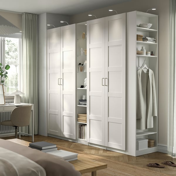 White PAX wardrobe with open/closed compartments, lighting, and shelves.