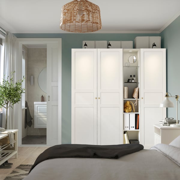 Modern white PAX wardrobe with shelves and drawers in bedroom.
