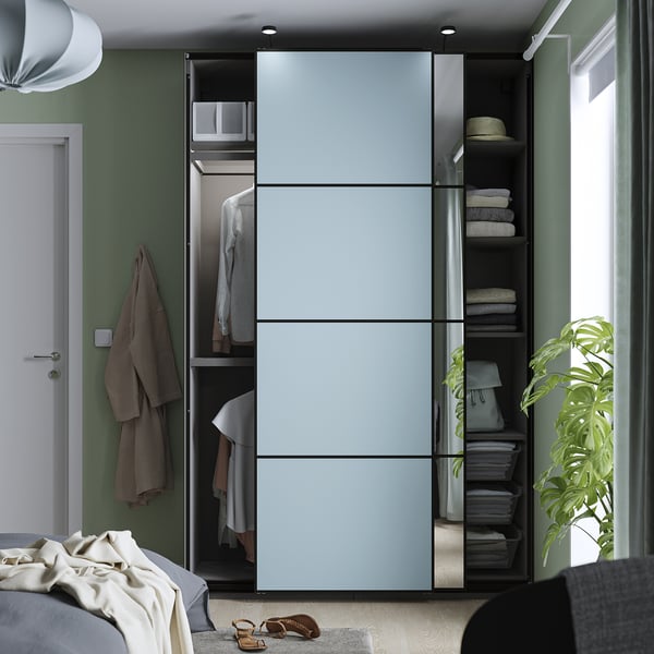 Modern wardrobe with sliding doors, showing organised clothes and storage.