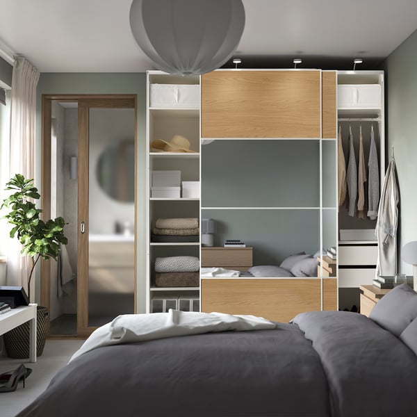 Modern bedroom with large PAX wardrobe, sliding doors, shelves, and hanging storage.