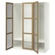 A white ikea PAX wardrobe with two open doors. The doors have wooden frames and frosted glass panels.