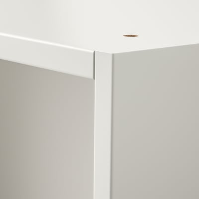 Clean, minimalist interior. White wall, ceiling, and wardrobe corner. Small, circular light fixture.