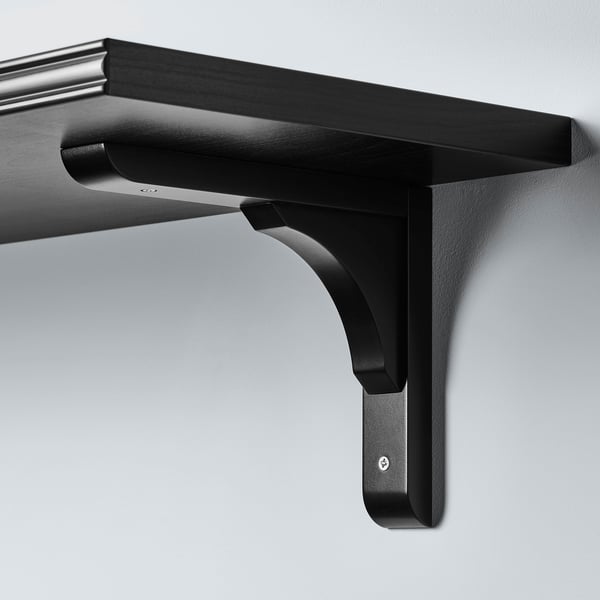 Black wall-mount shelf bracket, reversible, holding a dark shelf; sturdy design.