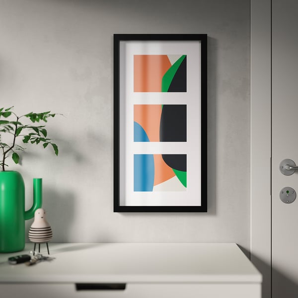 Abstract art with vibrant shapes framed, above white dresser. Green vase with leaves and figurine. Versatile frame.