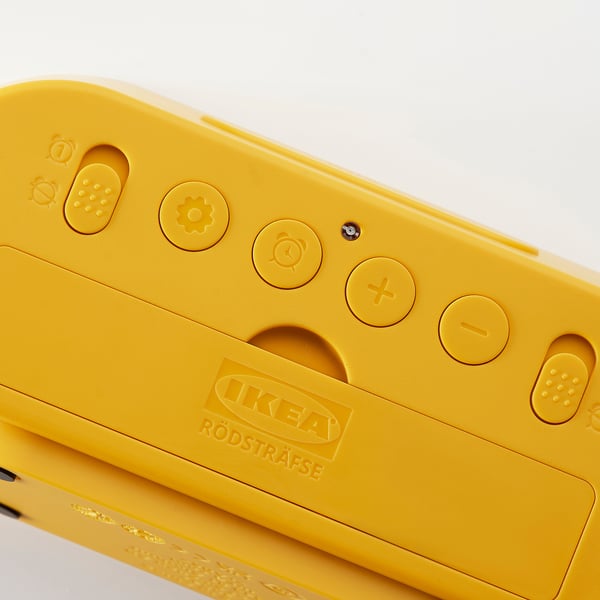 Bright yellow digital alarm clock with clear buttons, IKEA RÖDSTRÄFSE embossed, set against white background.