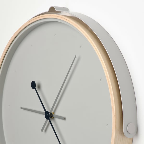Modern silent clock with minimalist design, light wood frame, and metal hands. Clean and sleek appearance.