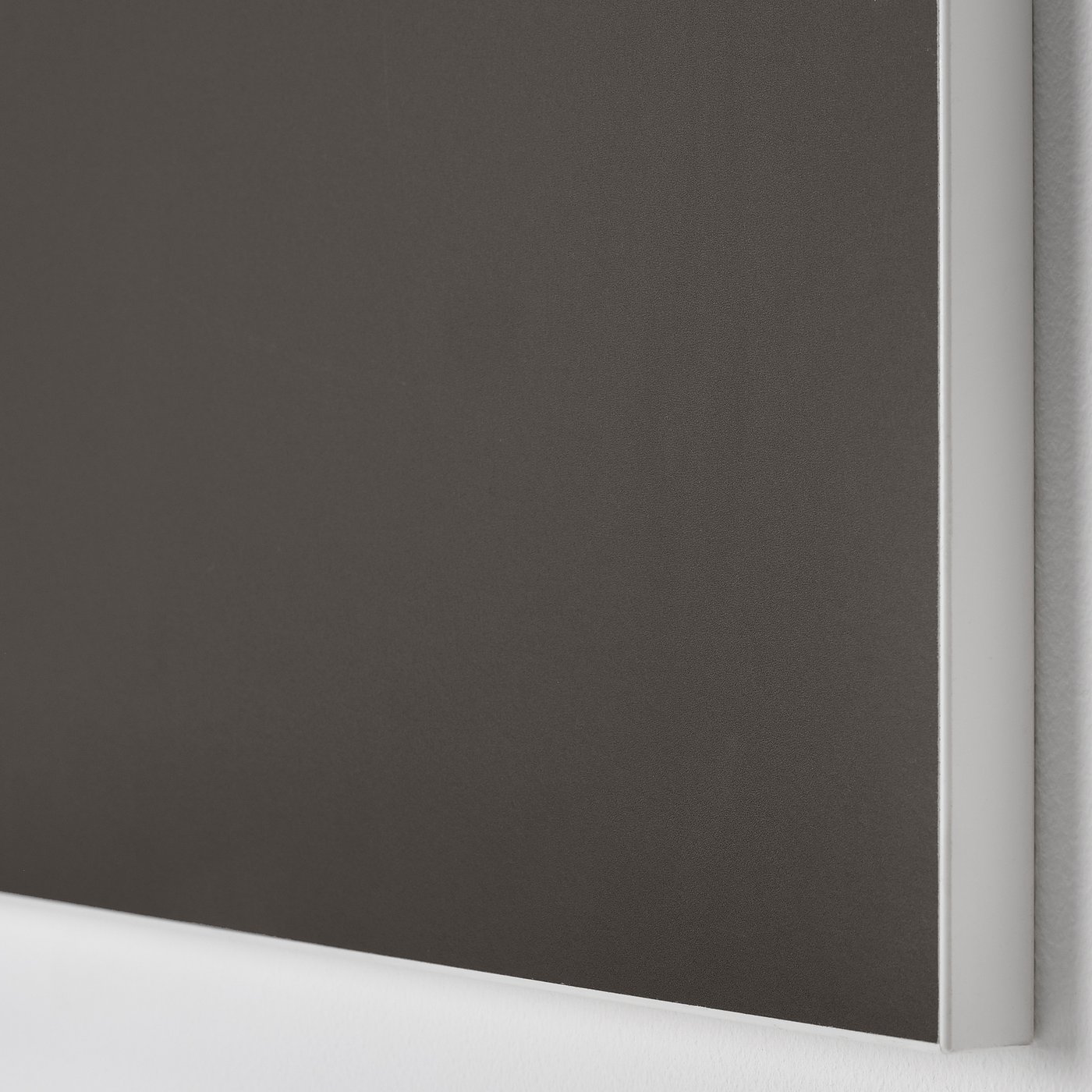 Close-up of sleek, black cabinet door made of smooth particle board with plastic edging, reflecting a modern, high-quality design.