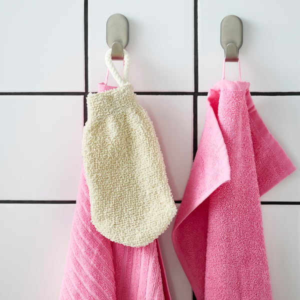 Hooks holding white scrub mitt & pink striped towels.
