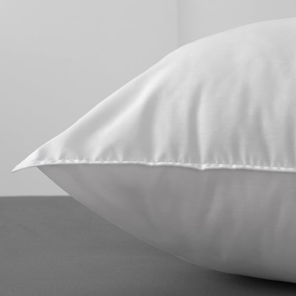 Close-up of a soft, plump pillow with stitched edges; high-quality fabric and filling.