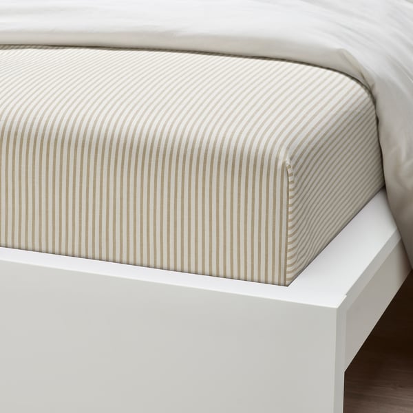 Crisp, light-colored bed sheet with thin beige stripes neatly arranged on a white bed frame, showcasing high-quality cotton texture.