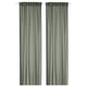 Two green STENFRÖ sheer curtains hang straight, offering a sense of calm. Made from recycled polyester, they diffuse sunlight, adding privacy.