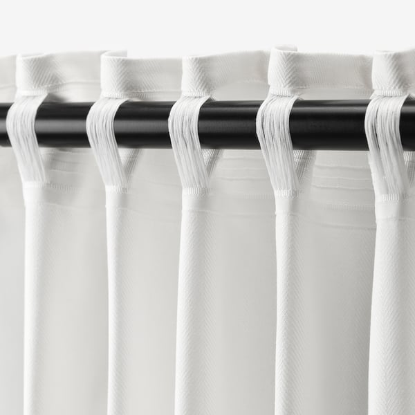 White curtains, drawn back with loops on black rod. Privacy and partial light philtre, adjustable pleats.