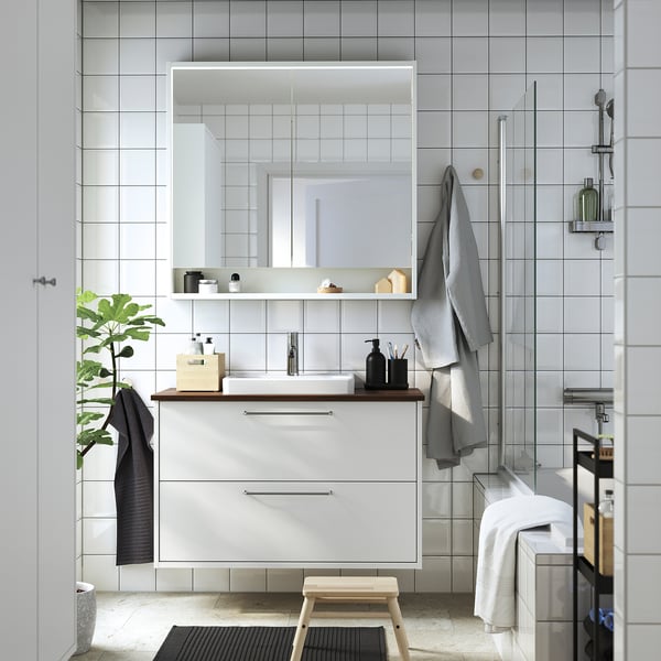 Modern bathroom with large mirror, white sink cabinet, black accessories, grey towels. TOLKEN walnut countertop looks warm and inviting.