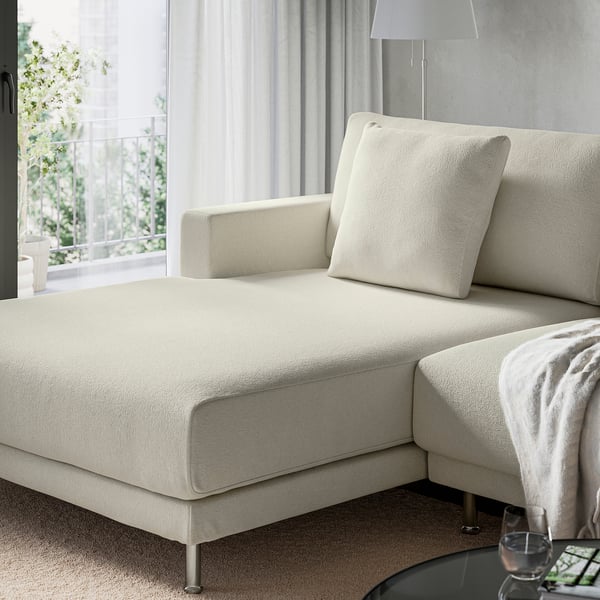 Cream sectional sofa with plush cushions near a window.