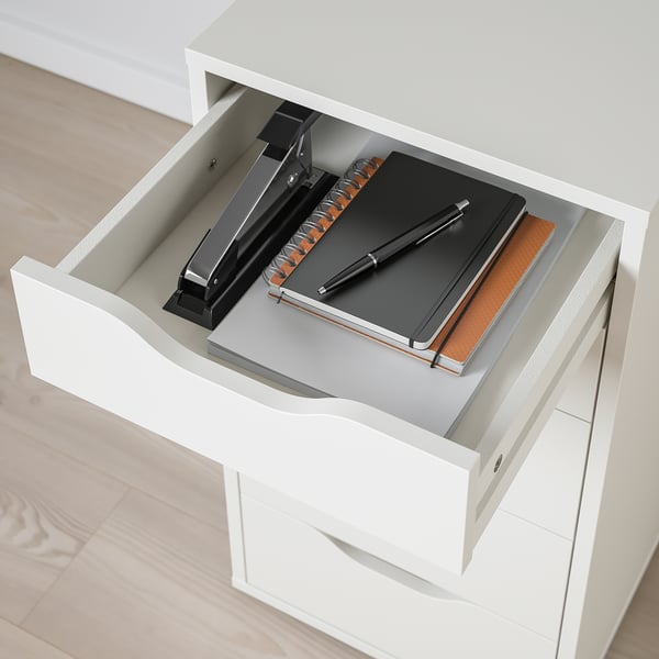 Avatud valge lauasahtel musta klammerdaja, märkmiku ja pliiatsiga. Viimistletud selg ja küljed.
