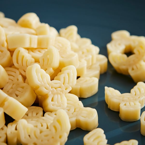 Kollase pasta hunnik, mis on kujundatud põdrapeade kujuliselt, ja lilled sinisel pinnal.