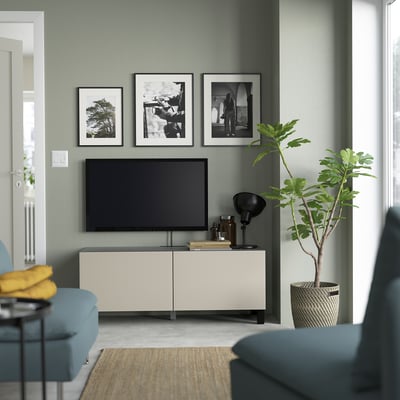 Kaasaegne hallide seintega elutuba, BESTÅ televiisor, lameekraaniga televiisor, lamp, raamatud, taim, sinine diivan, kollane padi, fotod - hubane ja stiilne.