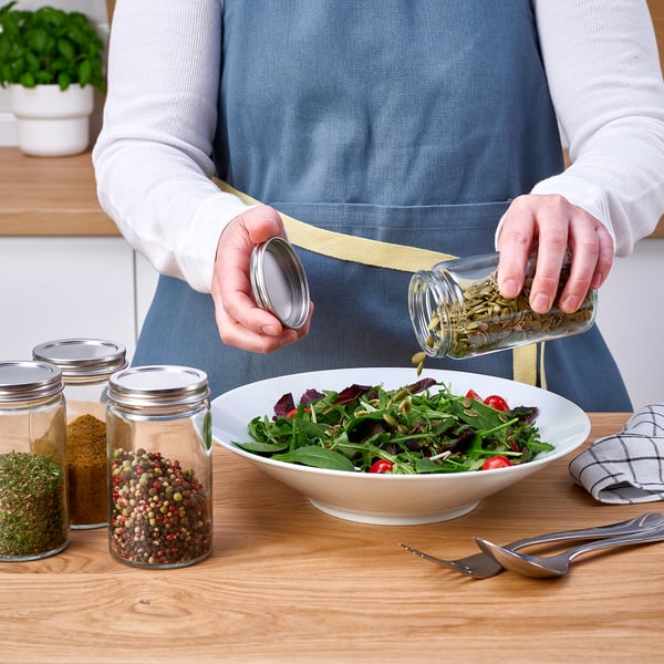 Inimene, kes maitsestab köögilaual salatit ürtidega CITRONHAJ vürtsipurgist, teised vürtsidega.