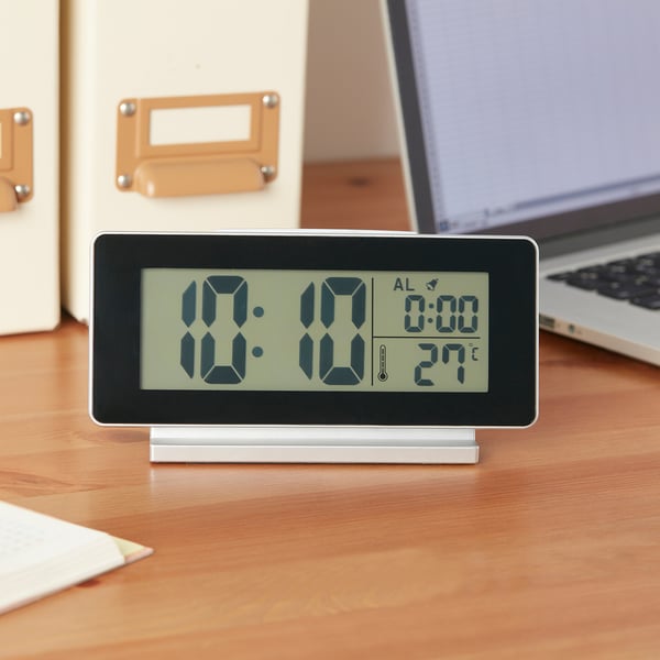 Must digitaalne äratuskell, mis näitab 10:10 ristkülikukujulisel alusel; Näitab kellaaega, äratust ja temperatuuri 27 °C.
