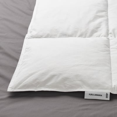 Voodil valge tekk, sildiga FJÄLLARNIKA. Näitab kvaliteetset kangast ja õmblusi.