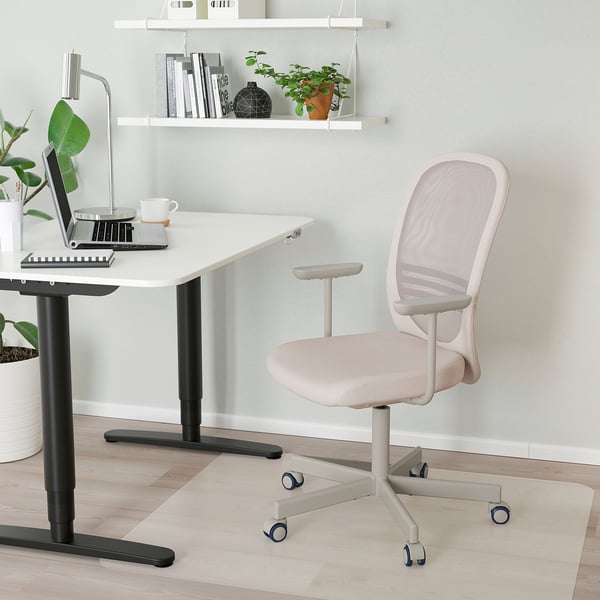 Valge IKEA FLINTAN võrkseljatoega kontoritool, sülearvutiga laua kõrval, kompaktne ja ergonoomiline pikkadeks töötundideks.