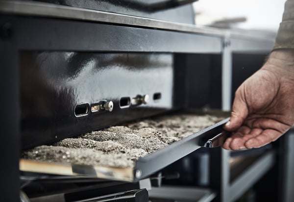 Söegrillide tuhatoosi väljatõmbamine. Must metallist grill roostevabast terasest detailidega.