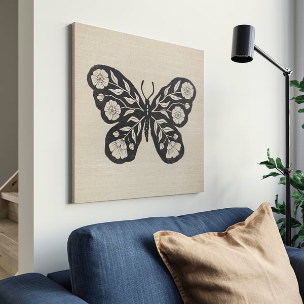 Beež lõuendikunst musta liblikaga sinise diivani kohal, osaline lamp.