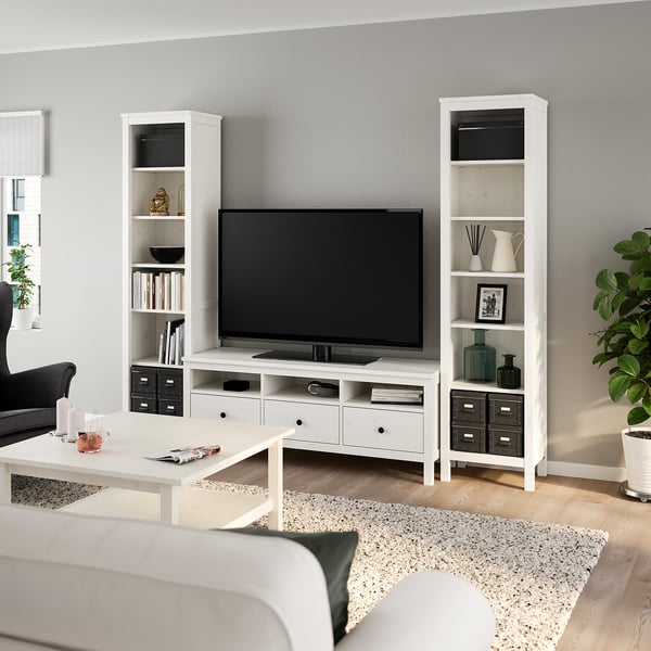 Kaasaegne elutuba HEMNES televiisori ja raamaturiiulitega, hallid seinad, beež vaip.