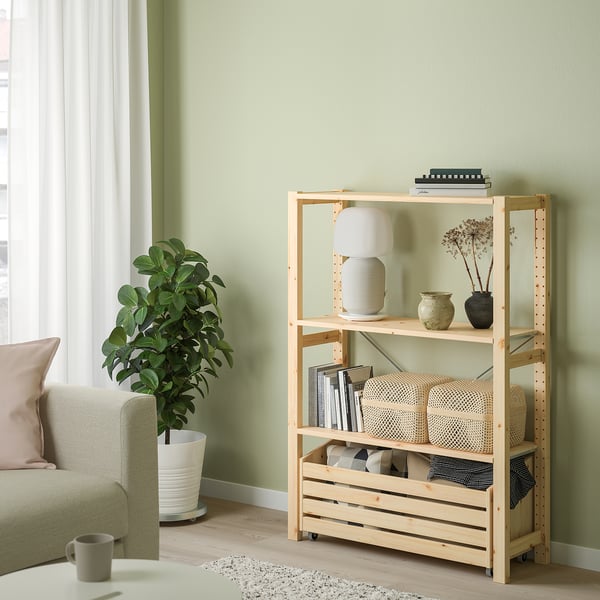 Kerge puidust IVAR riiul erinevate esemetega, suurem kui diivan ja taim selle kõrval.