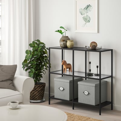 Valge KVARNVIK halli mustriga hoiukast riiulil, vooderdatud kangas ja taim .
