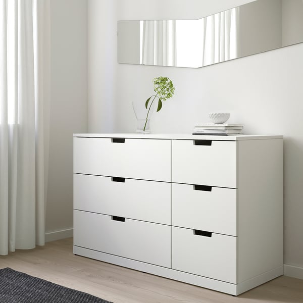 Ikea NORDLI 6 sahtliga kummut vastu seina, minimalistlik tuba, rohelise lillega vaas, raamatud.