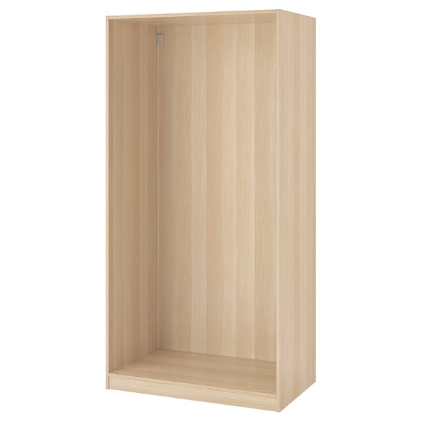 Valge ikea PAX garderoobiraam. See on ristkülikukujuline, siledate pindade ja vertikaalsete soontega, mis on mõeldud magamistoa esmatarbekaupade korraldamiseks.