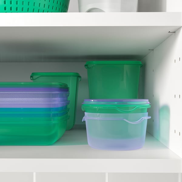 Rohelised ja lillad plastmahutid riiulitel toidu hoidmiseks.
