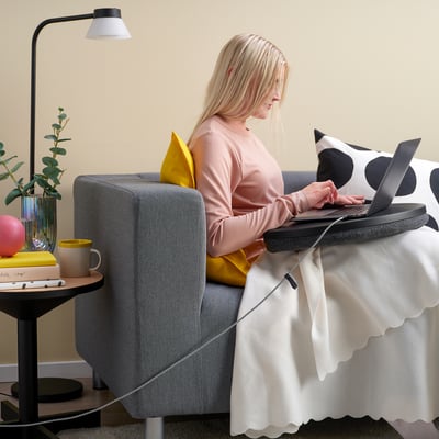 Naine, kes töötab sülearvutiga tugitoolis, valgustatud usb-c kaabel