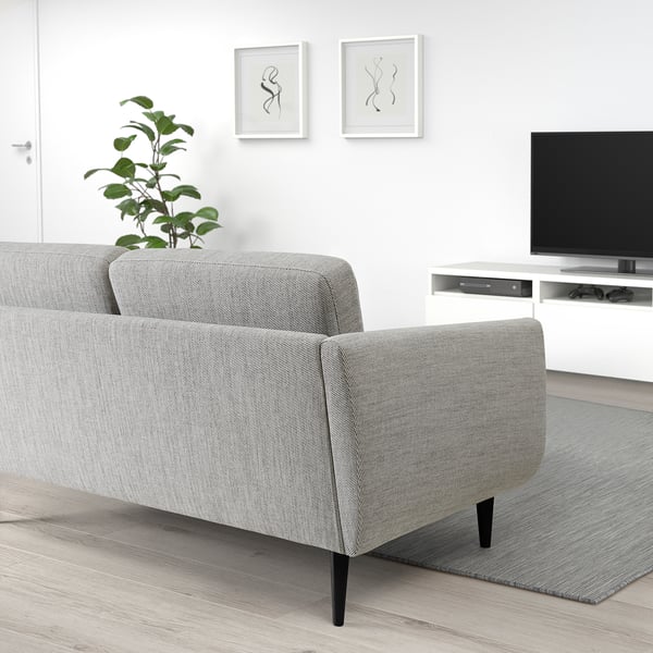 Kaasaegne elutuba SMEDSTORP diivani, televiisori, taime ja minimalistliku sisekujundusega.