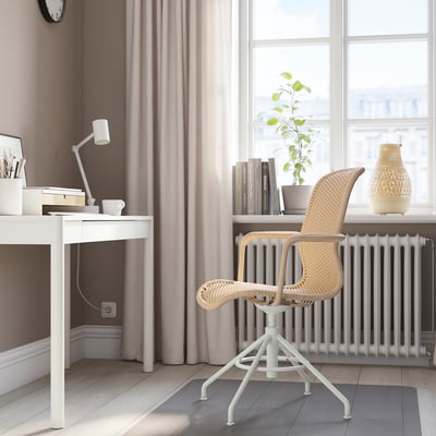 Minimalistlik kodukontor STIGBYGEL pöörleva tooli, väikese kirjutuslaua, sülearvuti, raamatute, lambi, taime ja loomuliku valgusega.
