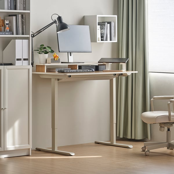 Minimalistlik kodukontor, kus on TRAVSPORT reguleeritav kirjutuslaud, valge tool, monitor, klaviatuur, must lamp, raamaturiiul ja kardinaakna.