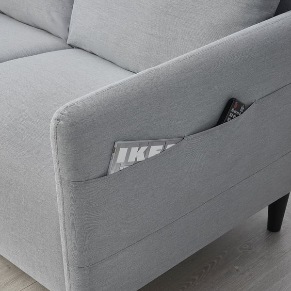 Grey sofa with side pocket holding a remote.