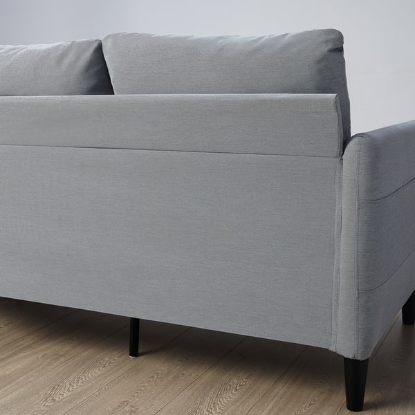 Grey three-seat sofa with side pockets, black legs.