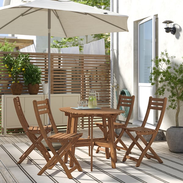 ASKHOLMEN brown acacia wood outdoor dining set with 4 foldable chairs & table, perfect for small spaces.