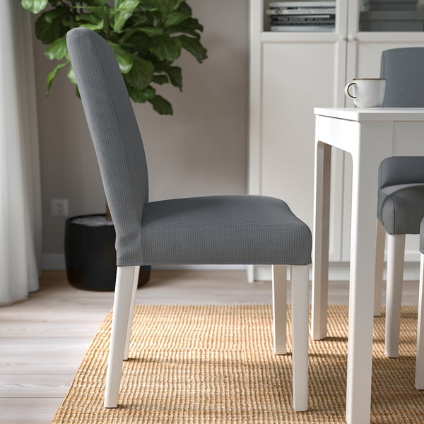Modern dining area with grey upholstered chair, white legs, and small white table.