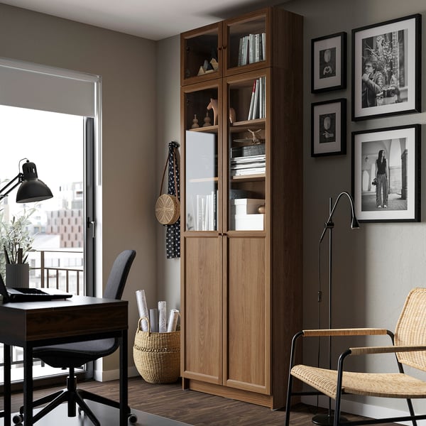 Home office with BILLY bookcase, desk, lamp, and window.